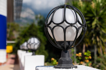 Outdoor round lighting lantern framed in a metal.