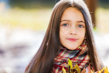 Portrait of young girl in a park on a sunny autumn day.