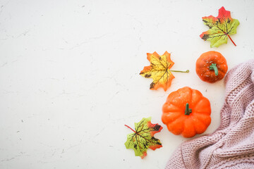 Autumn background with copy space at white marble table. Pumpkins, leaves, knitted scarf and fall...