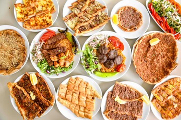 Delicious meat kebab with fresh vegetable salad served with variety of Turkish dishes and appetizers. Top view of assorted Turkish food and meze, tasty and healthy Mediterranean cuisine.