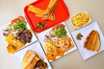 Delicious meat kebab with fresh vegetable salad served with variety of Turkish dishes and appetizers. Top view of assorted Turkish food and meze, tasty and healthy Mediterranean cuisine.