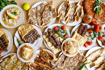 Delicious meat kebab with fresh vegetable salad served with variety of Turkish dishes and appetizers. Top view of assorted Turkish food and meze, tasty and healthy Mediterranean cuisine.