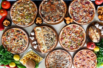 Traditional Turkish cuisine. Pizza, pita, pidesi, sucuk, hummus, kebab. Many dishes on the table. Serving dishes in restaurant. Background image. Top view, flat lay