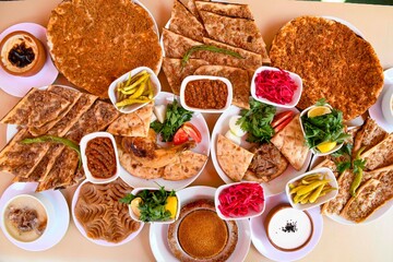 Delicious meat kebab with fresh vegetable salad served with variety of Turkish dishes and appetizers. Top view of assorted Turkish food and meze, tasty and healthy Mediterranean cuisine.