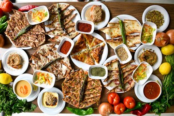 Delicious meat kebab with fresh vegetable salad served with variety of Turkish dishes and appetizers. Top view of assorted Turkish food and meze, tasty and healthy Mediterranean cuisine.