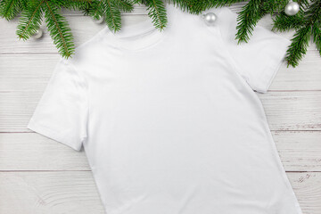 White womens cotton tshirt mockup with christmas tree branches and decoration. Design t shirt...