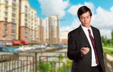Young man walking through the financial center with his cell phone