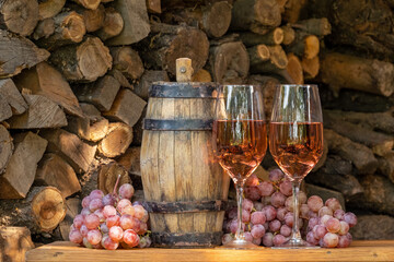 Rose wine in the wineglass and ripe grapes on wooden table. Grape harvest. Wine tasting culture. Sommelier pouring dessert wine in glass. Winery