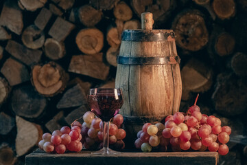 Rose wine in the wineglass and ripe grapes on wooden table. Grape harvest. Wine tasting culture. Sommelier pouring dessert wine in glass. Winery