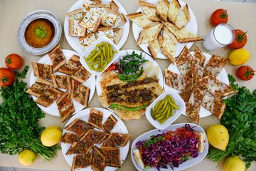 Delicious meat kebab with fresh vegetable salad served with variety of Turkish dishes and appetizers. Top view of assorted Turkish food and meze, tasty and healthy Mediterranean cuisine.