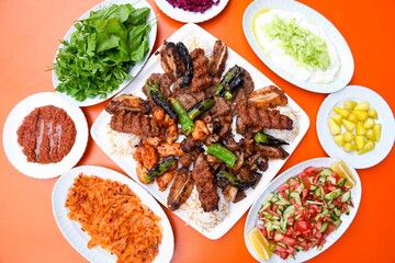 Delicious meat kebab with fresh vegetable salad served with variety of Turkish dishes and appetizers. Top view of assorted Turkish food and meze, tasty and healthy Mediterranean cuisine.