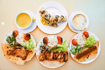 Delicious meat kebab with fresh vegetable salad served with variety of Turkish dishes and appetizers. Top view of assorted Turkish food and meze, tasty and healthy Mediterranean cuisine.
