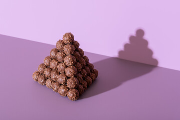 Chocolate truffles pyramid on a purple background