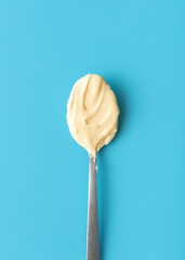 White chocolate spoon above view on a blue background