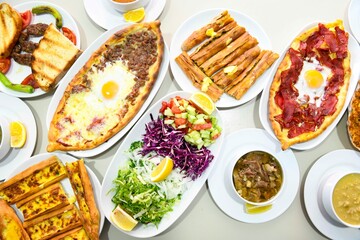 Delicious meat kebab with fresh vegetable salad served with variety of Turkish dishes and appetizers. Top view of assorted Turkish food and meze, tasty and healthy Mediterranean cuisine.