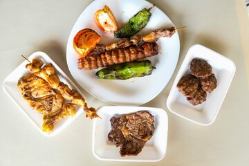 Delicious meat kebab with fresh vegetable salad served with variety of Turkish dishes and appetizers. Top view of assorted Turkish food and meze, tasty and healthy Mediterranean cuisine.