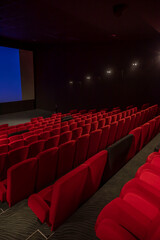 salle de cinéma avec de beaux fauteuils rouges et noirs