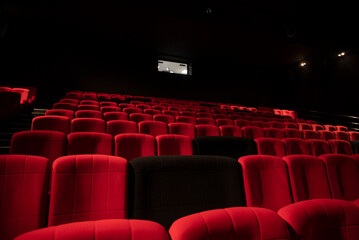 Salle de cinéma avec des fauteuils confortables rouges et noirs - obrazy, fototapety, plakaty