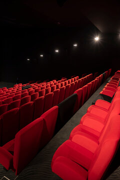 Salle de cin&eacute;ma et de spectacle avec des fauteuils rouges et noirs