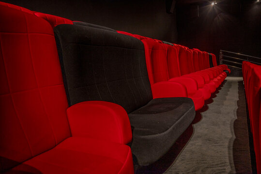 rang&eacute;e de fauteuils de cin&eacute;ma rouges et noirs &eacute;clair&eacute;s