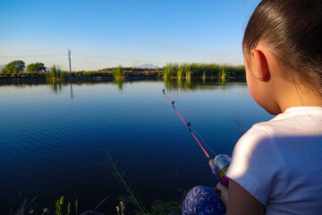 Niña pesca en el lago