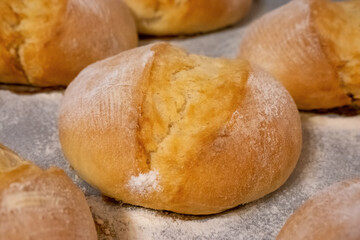 homemade crispy buns, fresh from the oven on the tray, for breakfast, bakery, bread, flour on an kitchen counter, cooking, baking, small bread