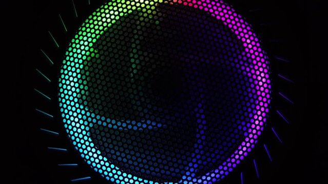 Colorful led lights of computer fan shines through the protective grid. illumination glows in the dark