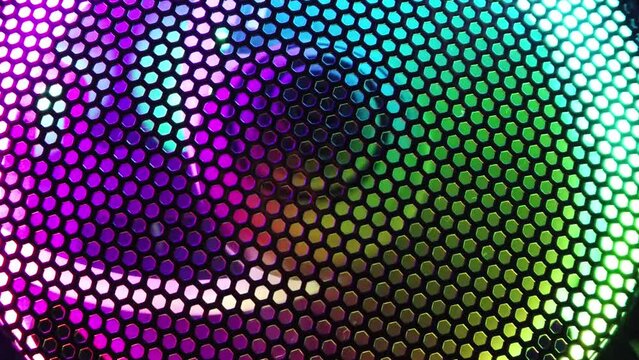 Colorful led lights of computer fan shines through the protective grid. illumination glows in the dark. slow motion