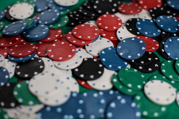 Casino poker chips colorful gaming pieces lie on the game table in the stack. Background for gambling, casino, business, poker. many colorful casino chips. Casino chips on green velvet. Soft focus.