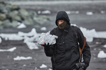 Fototapeta na wymiar Photographer picking up pieces of icebergs