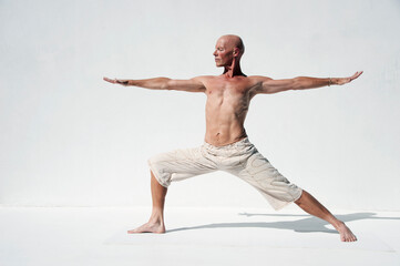 Obraz premium Man practicing perfect yoga photographed against a white background. 