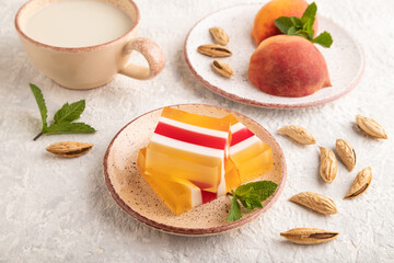 Almond milk and peach jelly on gray concrete. side view.