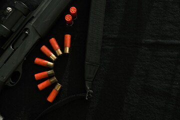 Weapon on black cloth: rifle, shells,top view. Top view of rifle, shells on black cloth background