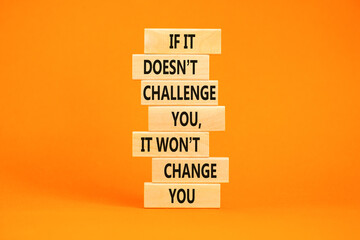 Challenge to change symbol. Concept words If it does not challenge you it wont change you on blocks on a beautiful orange table orange background. Business motivational and challenge concept.