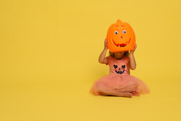 girl playing with a halloween pumpkin