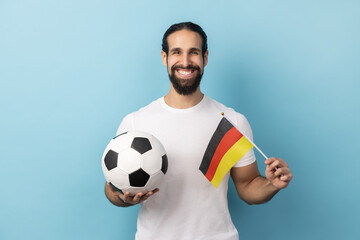 Portrait of smiling man with beard wearing white T-shirt supporting german soccer team on...