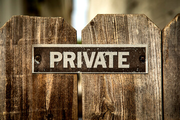 Black scratched sign stating Private on a wood fence