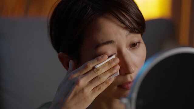 コットンでメイクを落とす女性（美容・化粧・メイク・夜）