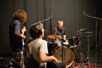 Music band playing music and rehearsing in recording studio