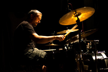 Drummer in rock band recording music in the professional recording studio
