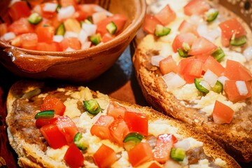 Mexican Molletes, traditional food with bread, beans, cheese, tomato and chili