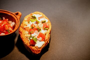 Mexican Molletes, traditional food with bread, beans, cheese, tomato and chili