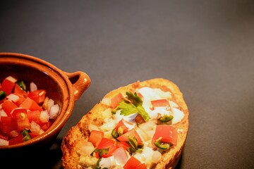 Mexican Molletes, traditional food with bread, beans, cheese, tomato and chili