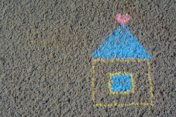 House with heart drawn by blue and yellow chalk on asphalt, top view. Space for text