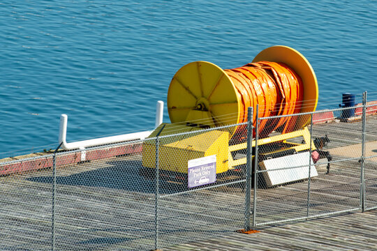 An industrial reel of orange oil sorbents spills containment boom absorbent material for environmental accidents and disasters at sea such as oil spills, chemicals, poison, waste, and toxic materials.