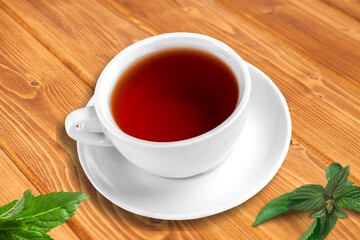 Ice tea with mint in cup with fresh mint leaves around. Homemade cold refreshing drink.