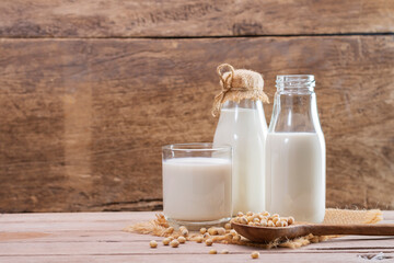 Soy milk in a glass with soybeans on a wooden table organic drink high protein healthy breakfast agricultural produce vegetarian