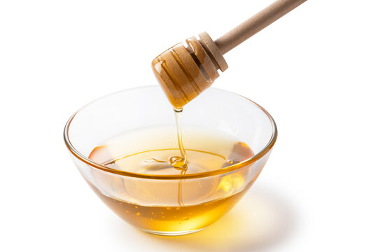Honey and honey dippers in glass bowls on white background.