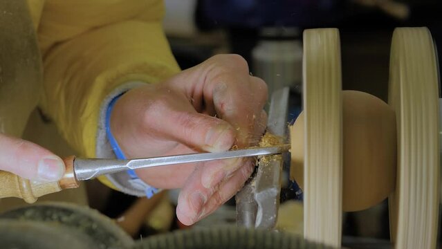 Slow Motion: Man Carpenter Using Chisel For Shaping Decorative Wooden Ball On Turning Lathe Machine With Many Shavings - Side View, Close Up. Carpentry, Hobby, Craftsmanship And Manufacturing Concept