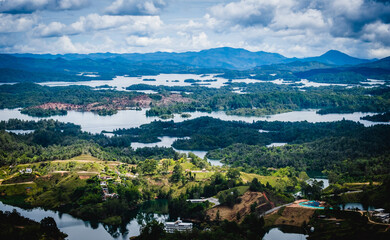 Fototapeta na wymiar Aerial Drone Vision Above Guatape Lakes and Islands near Medellin Colombia Green Unpolluted Town with Blue Water Zoom Out of Natural Landscape, Travel Destination in Latin America